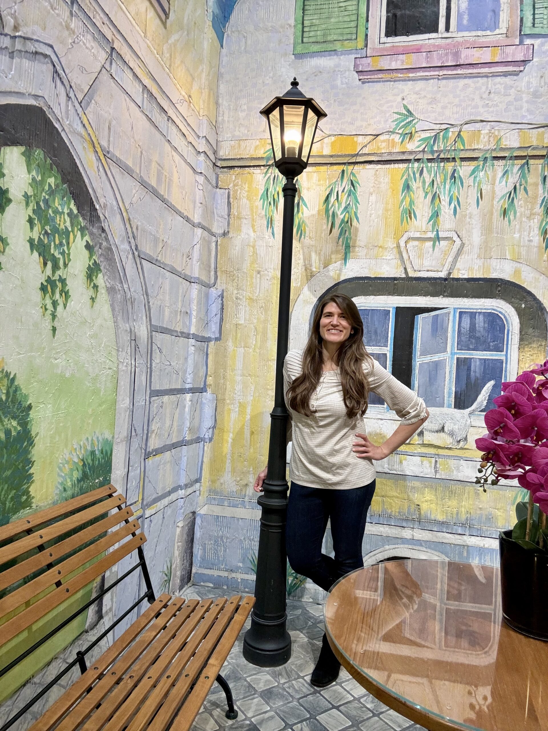 Allie in front of wall mural with lamp post at Hotel Adler