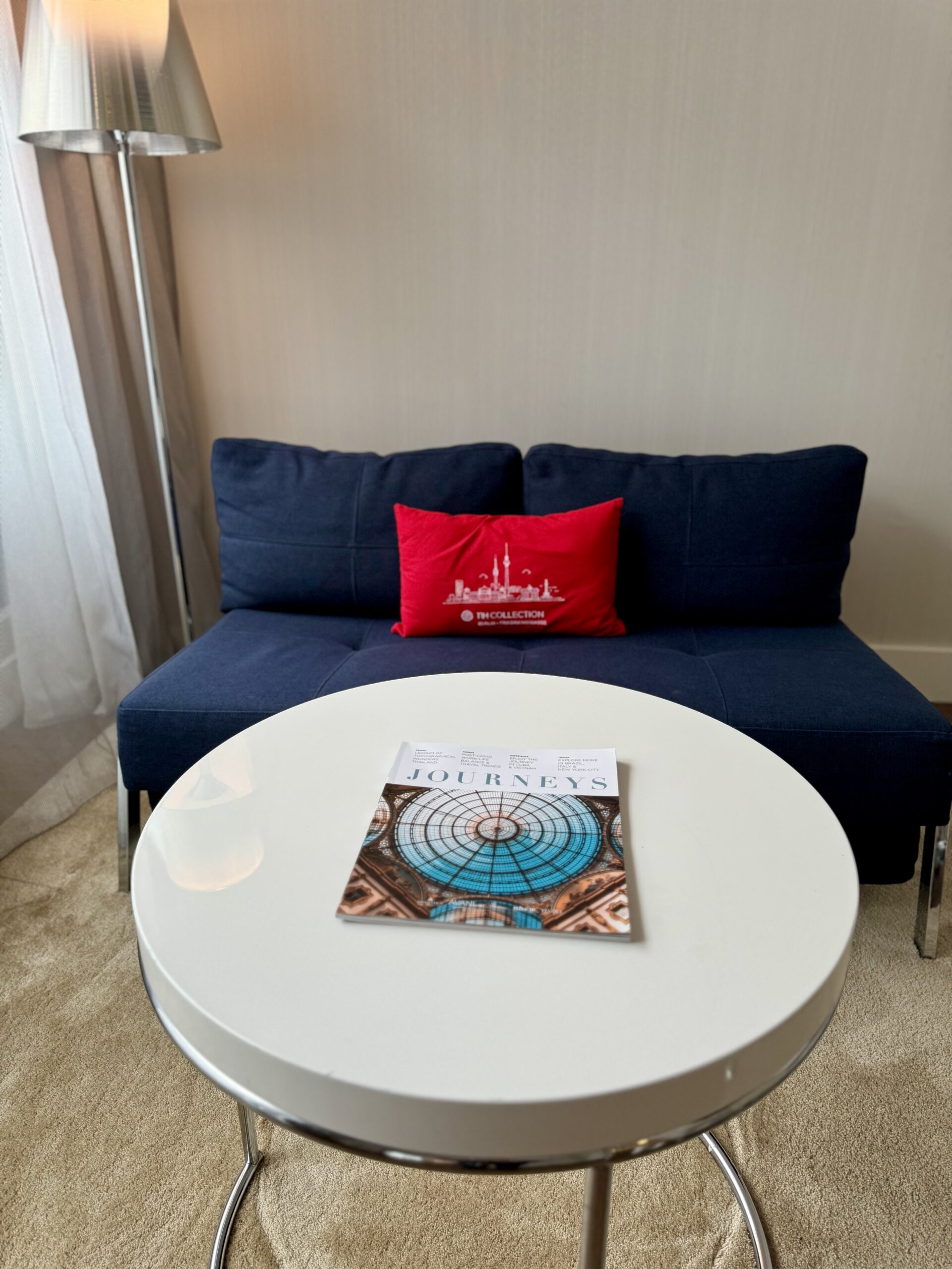 Couch with red Berlin pillow and coffee table with magazine